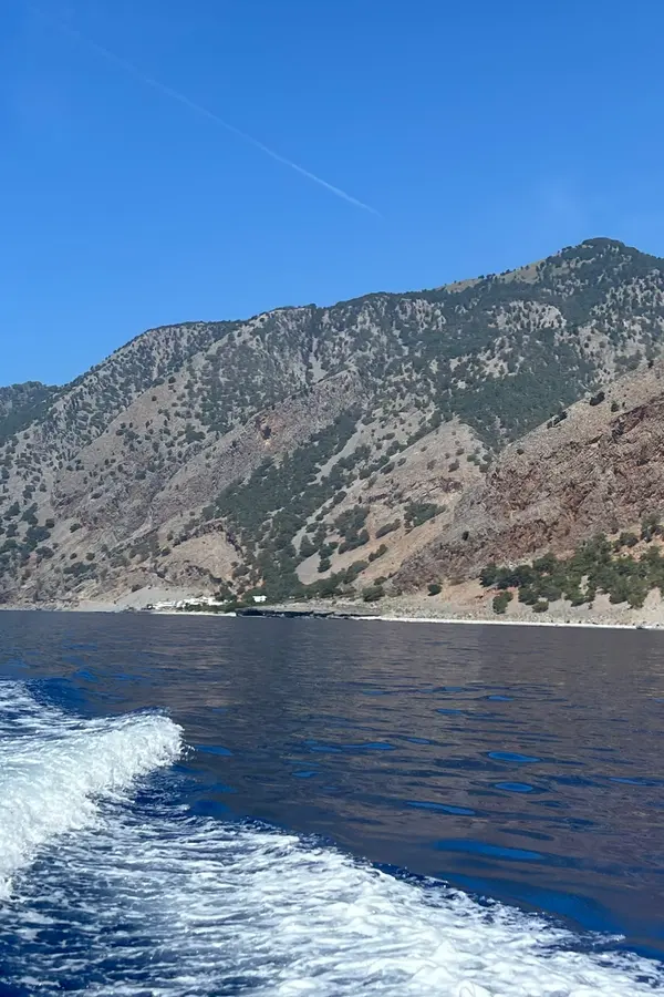 Boats arriving in the picturesque village of Agia Roumeli, set against dramatic southern Cretan cliffs.
